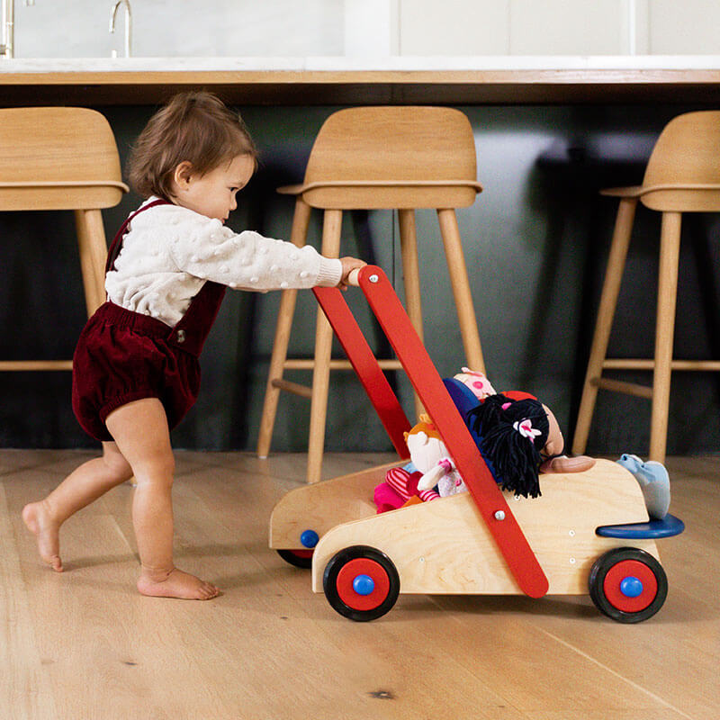 1 year old pushing a HABA Wooden Baby Walker across the floor